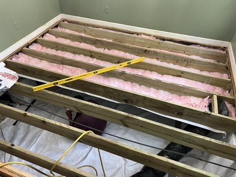 New floor joists and insulation installed before new subfloor and flooring.